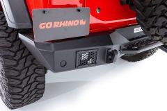 Close-up view of a black aftermarket bumper on the rear of a red vehicle, featuring a "GO RHINO" license plate and a mesh vent.