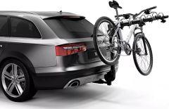 A gray and black Audi SUV with a silver bicycle mounted on a hitch rack at the back, highlighting its modern design.