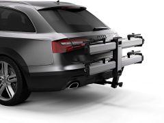 A silver Audi vehicle with a bike rack attached to the rear, featuring two horizontal bike holders.