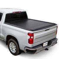 Silver Chevrolet Silverado pickup truck with a black roll-up tonneau cover resting on a flat surface.