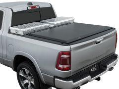 Silver pickup truck with black tonneau cover and diamond plated storage box.