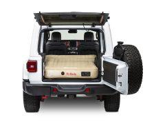 White Jeep with open trunk and tan air mattress.