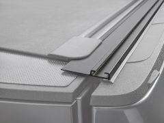 Close-up of a black plastic trim piece on a textured surface.