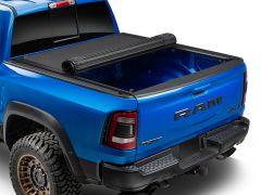 Blue Ram truck with partially rolled up tonneau cover.