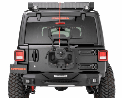 Rear view of a black off-road vehicle with rugged tires and aftermarket modification, including a roof-mounted light bar and "GO RHINO" branding.