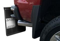 A red pickup truck rear featuring a textured black mud flap with a metallic "ROCK TAMERS" plate, and a visible chrome exhaust pipe.

Transcribed Text:

ROCK TAMERS
HOT SURFACE