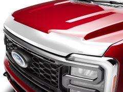 A red GMC truck front view showing a chrome grille with horizontal and vertical bars, featuring the GMC logo in red. The headlights have LED lighting strips, emphasizing a bold design.