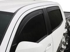 Close-up of a white pickup truck with tinted windows and aerodynamic widow visors, featuring a black graphic design on the side.