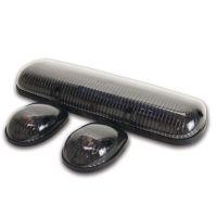 Three automotive lights in a triangular layout, featuring one long rectangular light and two smaller oval lights, all in glossy black with dark tinted casings.