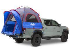 A light gray pickup truck with a blue and red tent attached to its bed, showcasing a dual peak design and mesh panels for ventilation.