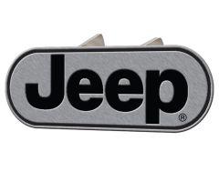 A metallic oval logo featuring the word "Jeep" in bold black letters on a brushed silver background.