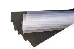 A layered stack of translucent white sheets on top of a dark textured material.