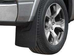 Close-up view of a vehicle's front right wheel, featuring a silver alloy rim, a textured tire labeled "Dueler H/L," and a black mud flap.