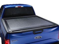Rear view of a blue Ford F-150 truck featuring a textured black bed cover, partially closed.
