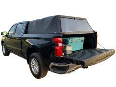 Black pickup truck with cooler in open tailgate.