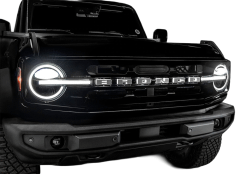 Front view of a black Ford Bronco showcasing its grille with the name "BRONCO" in silver letters and round headlights.