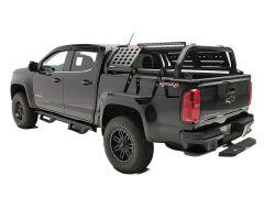 Black Chevrolet Colorado pickup truck with a customized metal rack, showcasing a modern design and rugged tires.