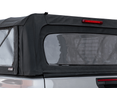 Close-up of a black soft cover on a vehicle, featuring clear side windows and a red brake light on top against a white background.