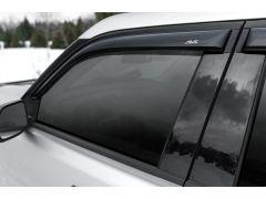 Car window with black trim and AVS logo.