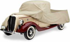 Vintage car covered with beige protective cover.