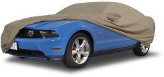 Blue car covered with protective beige car cover.