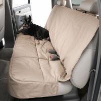 Black schnauzer dog on beige car seat protector.