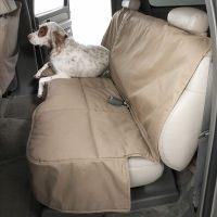 White dog with brown spots on car seat protector.