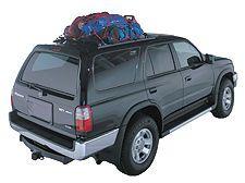 Gray SUV with luggage on roof rack from rear.