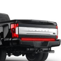 Rear view of a black Ford truck tailgate with silver trim, illuminated brake lights, and "LIMITED SUPER DUTY" labels.