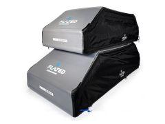 Stacked inflatable rooftop cargo carriers with gray and black exteriors, featuring the "Flated" logo. The carriers exude a modern, functional design.