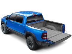 A blue pickup truck with an open, carpeted bed is shown. The truck's rugged design and black accents convey durability and utility.