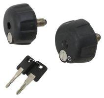 Two black, rounded knobs with textured surfaces and metal screws, accompanied by two metal keys on a flat surface.