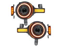 Two circular car headlights with dual-tone LED halos in white and orange, attached indicators are lit.