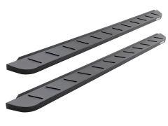 Two black vehicle running boards with diagonal grooves for traction, positioned parallel on a white background.