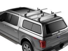 Aerial view of a gray Ford pickup truck's roof with silver crossbars for cargo, featuring dark-tinted windows and an "FX4 OFF-ROAD" badge.