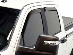 Close-up of a white pickup truck's tinted window and side mirror, showcasing black trim.